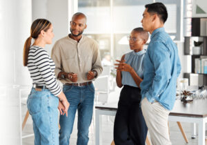 Group of diverse businesspeople having a meeting in a modern office at work. Business professionals talking and sharing ideas. Businesspeople planning together - WorldTone