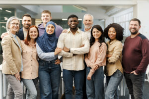 Group portrait of smiling multiracial business people looking at camera in modern office. Meeting - WorldTone